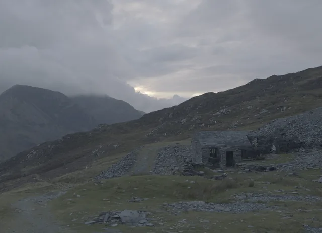 Ruined stone buildings under a moody Lakeland sky.
