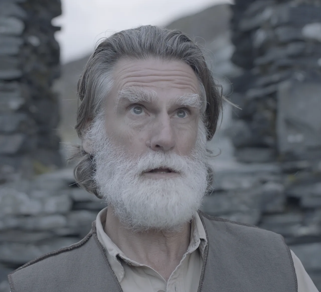 Still from Upper Air: Isaac, an older man with a white beard, on a sunlit fellside.