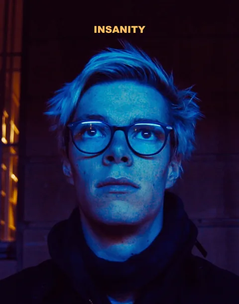 Insanity poster: a young man in glasses lit in cold blue light.